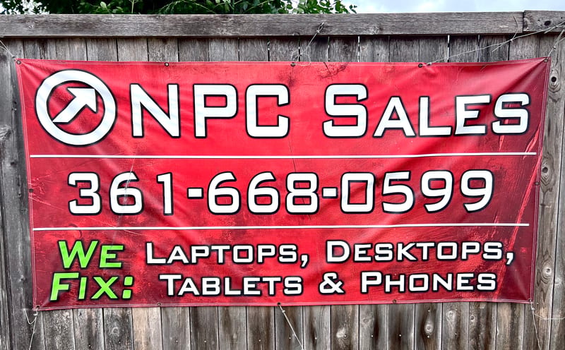 Red NPC Sales vinyl banner hanging on a fence