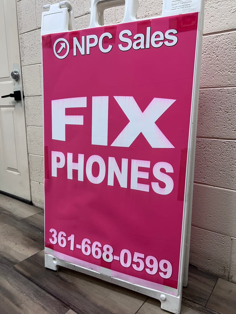 Pink NPC Sales 'Fix Phones' sandwich-board sign printed in-house